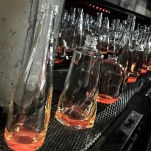 Bouteilles en verre : les produits issus du processus de production entrent dans le four de désenfumage